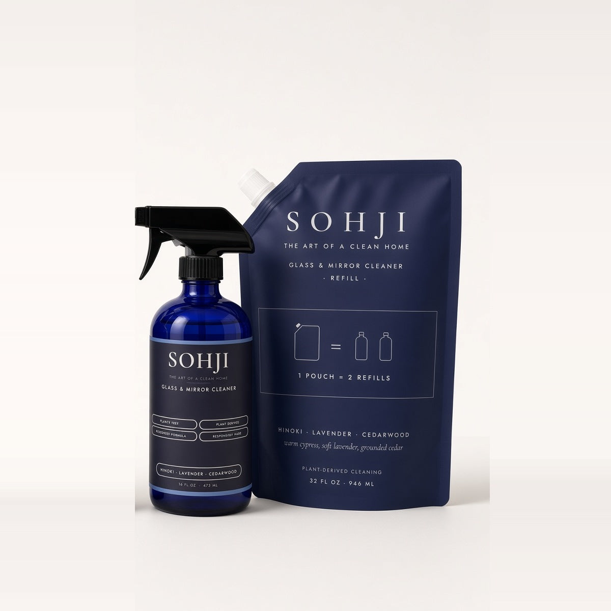 SOHJI Glass & Mirror Set: Glass & Mirror Cleaner cobalt glass spray bottle next to its navy 32 fl oz refill pouch